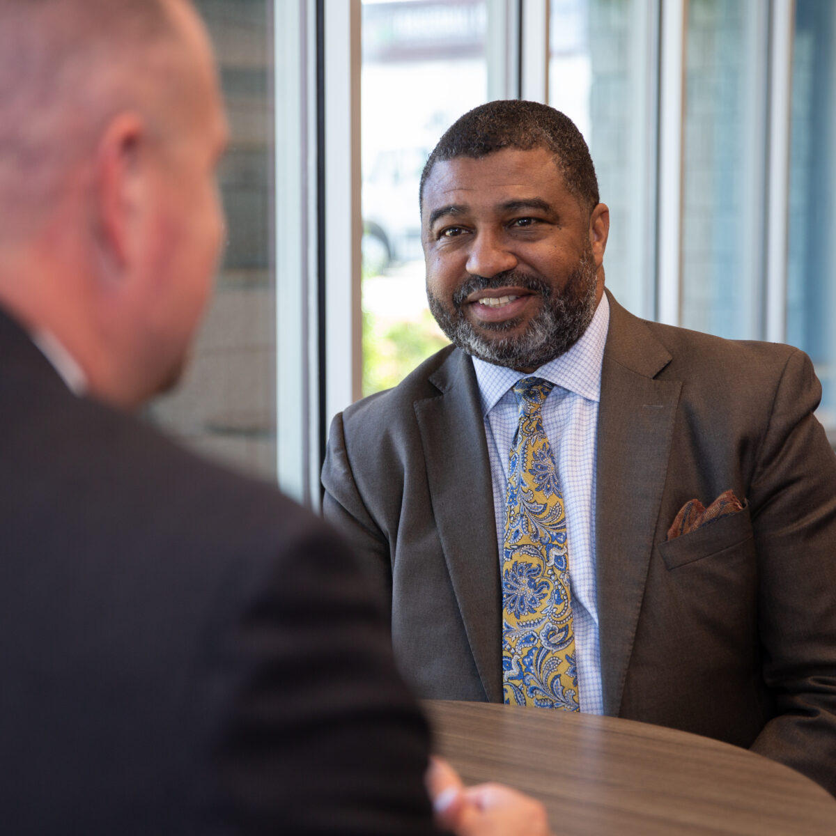 Dr. Russell W. Booker, CEO of Cradle to Career Network member Spartanburg Academic Movement, smiles at another person standing across from him.