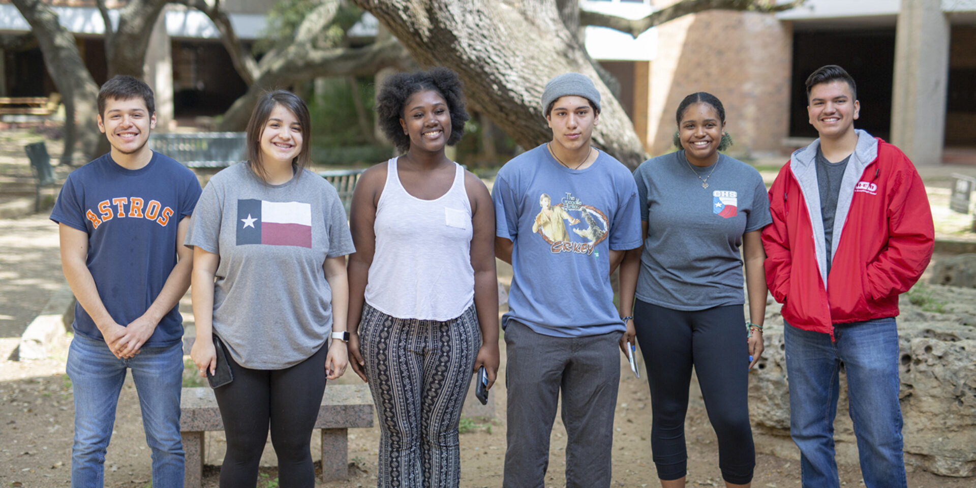 A group of six high-school aged students stand smiling at the camera.